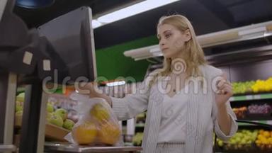 超市里的一个金发女孩用电子秤称着橘子，压着摆件，摆件上放着篮子